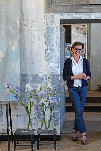 Portrait of Claire Basler at her home with vases of irises
