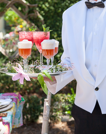 Orange and pink cocktails on a silver platter.