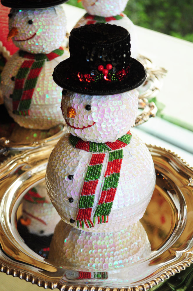 Sequined snowman ornaments standing on silver plates