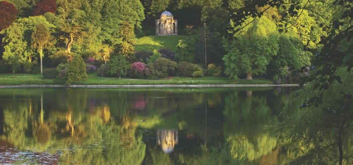 Panoramic view of the Temple of Apollo reflected in the lake at Stourhead, Wiltshire, in May.