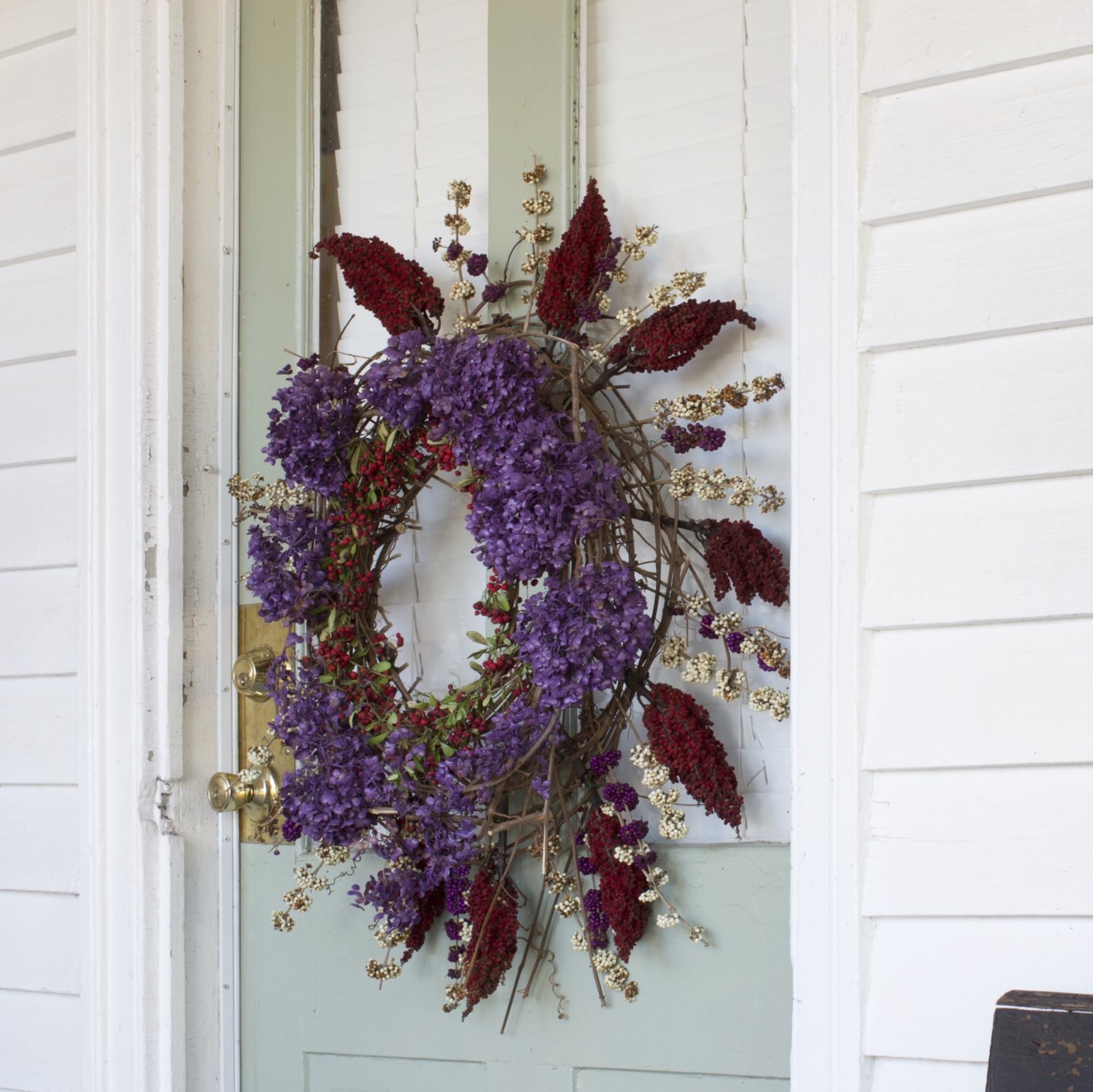 A wreath made of dried purple hydrangeas, pyracantha, sumac, and beauty berries hangs on Ryan Gainey's cottage door.
