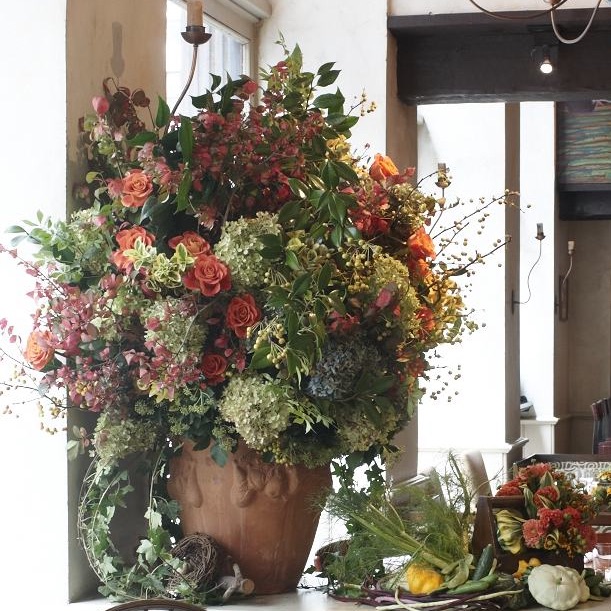 An autumn arrangement of crab apple, burning bush, roses, hydrangeas, kale, celosia, and ‘Persian Carpet’ zinnias greets guests as they enter Gramercy Tavern's dining room. Designed by Roberta Bendavid.