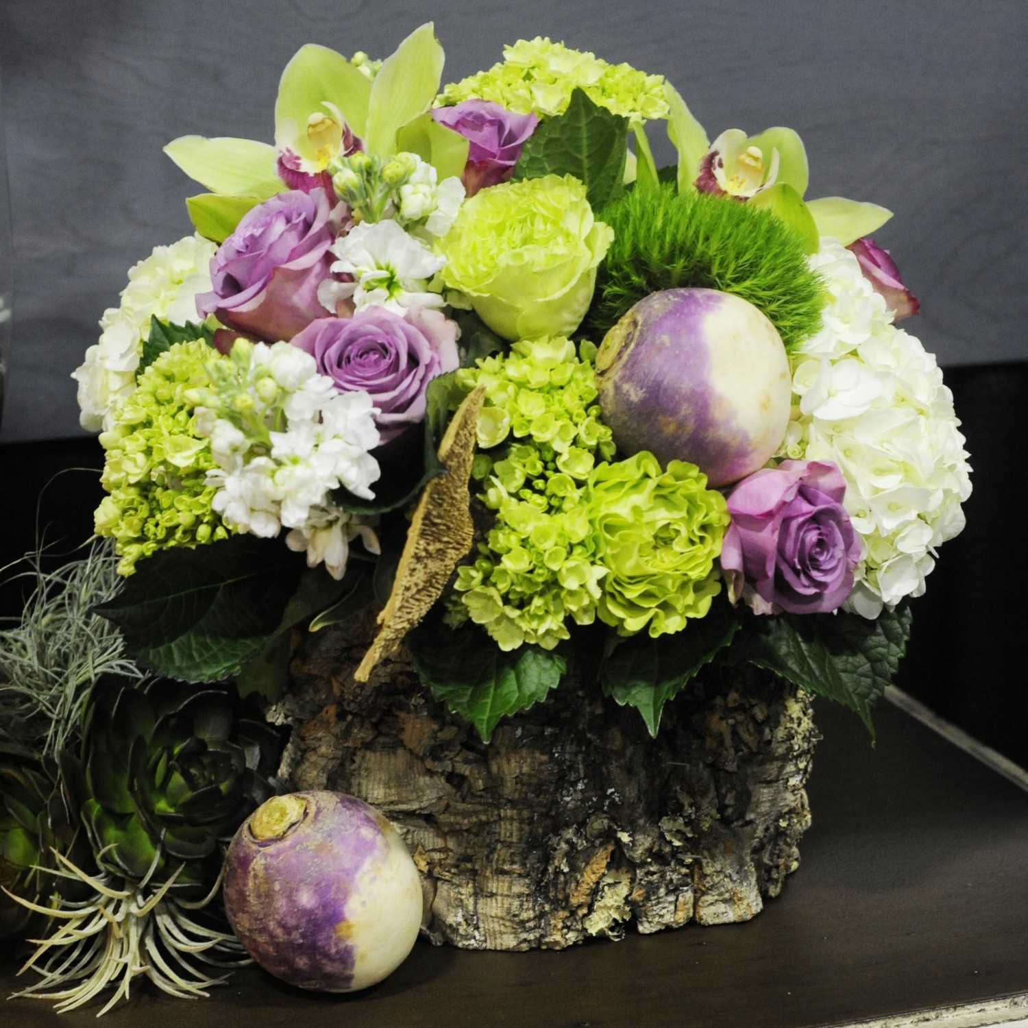A cork container holds an arrangement of hydrangeas, ‘Cool Water’ and ‘Super Green’ roses, ‘Green Trick’ dianthus, white stock, cymbidium orchids, and turnips at Cachepot in Knoxville, Tennessee.