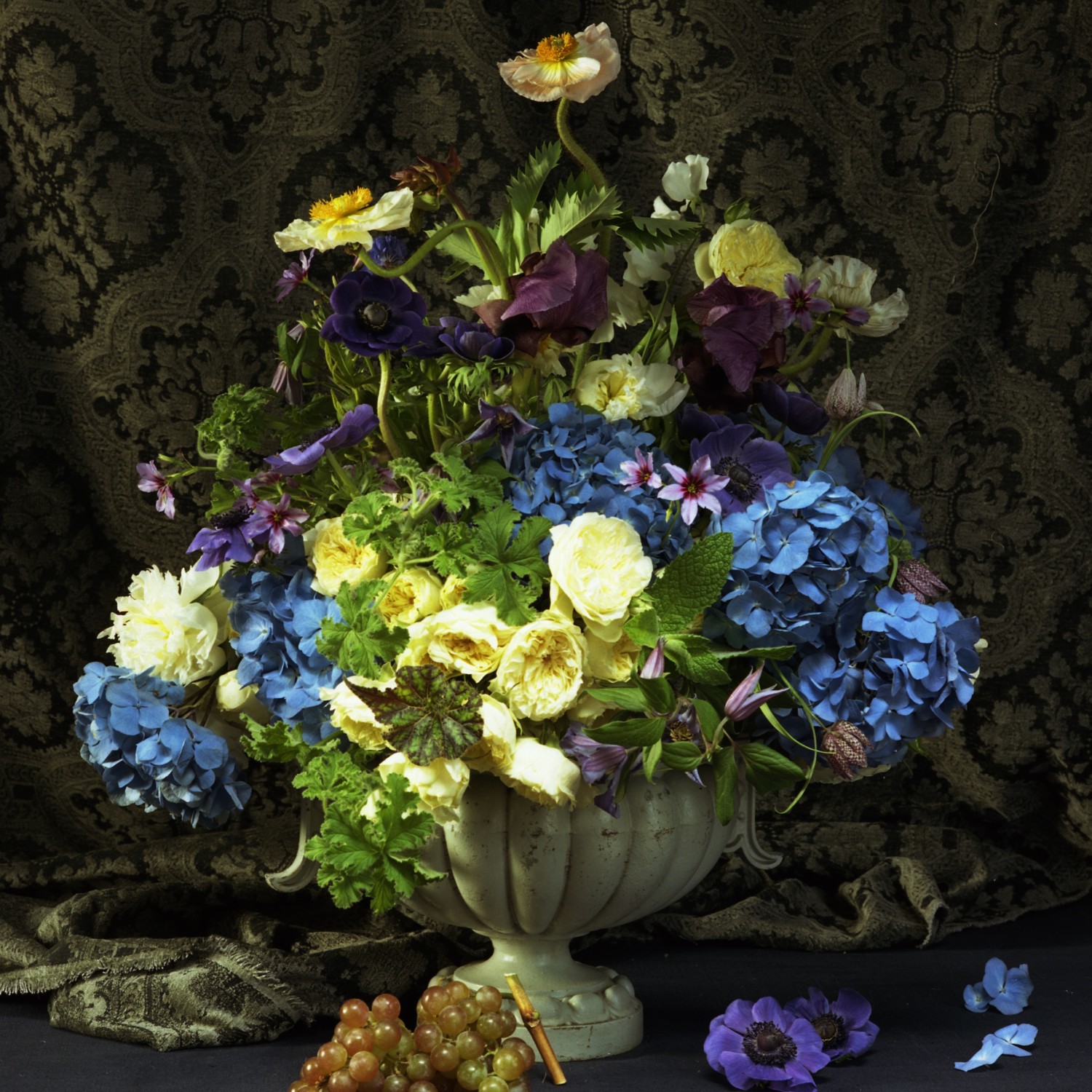Arrangement of yellow peonies and garden roses pop against nautical-blue hydrangeas and violet anemones, designed by Lewis Miller.
