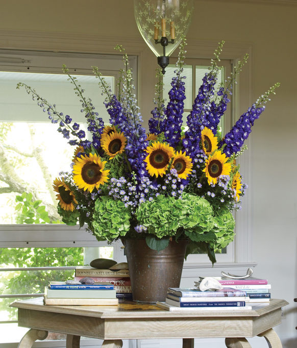Arrangement of sunflowers, delphinium, and hydrangeas designed by Michael Grim