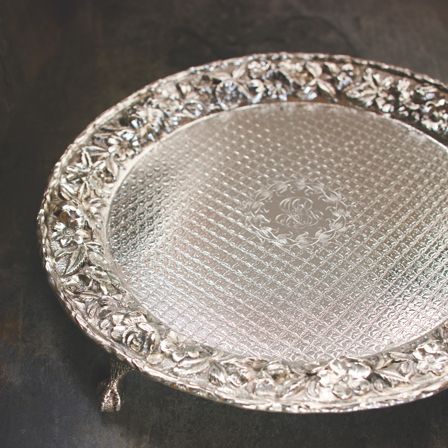 An antique monogrammed footed repoussé silver serving tray (Kirk Stieff).