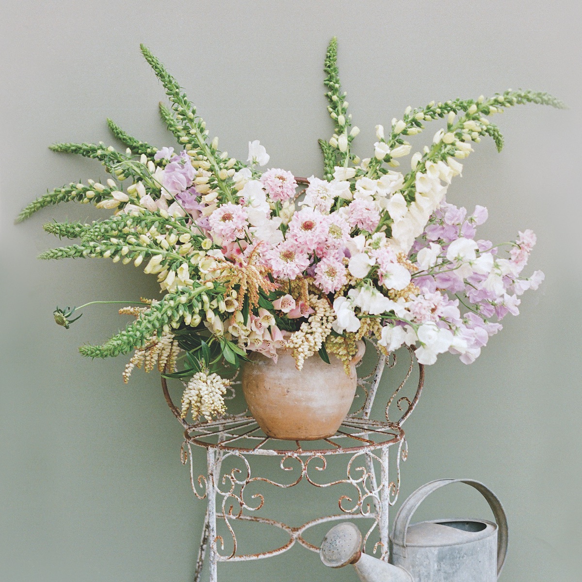 Tuscan jar with pink and white blossoms (sprays of foxglove, scabiosas, Japanese sweet peas, and Pieris japonica)