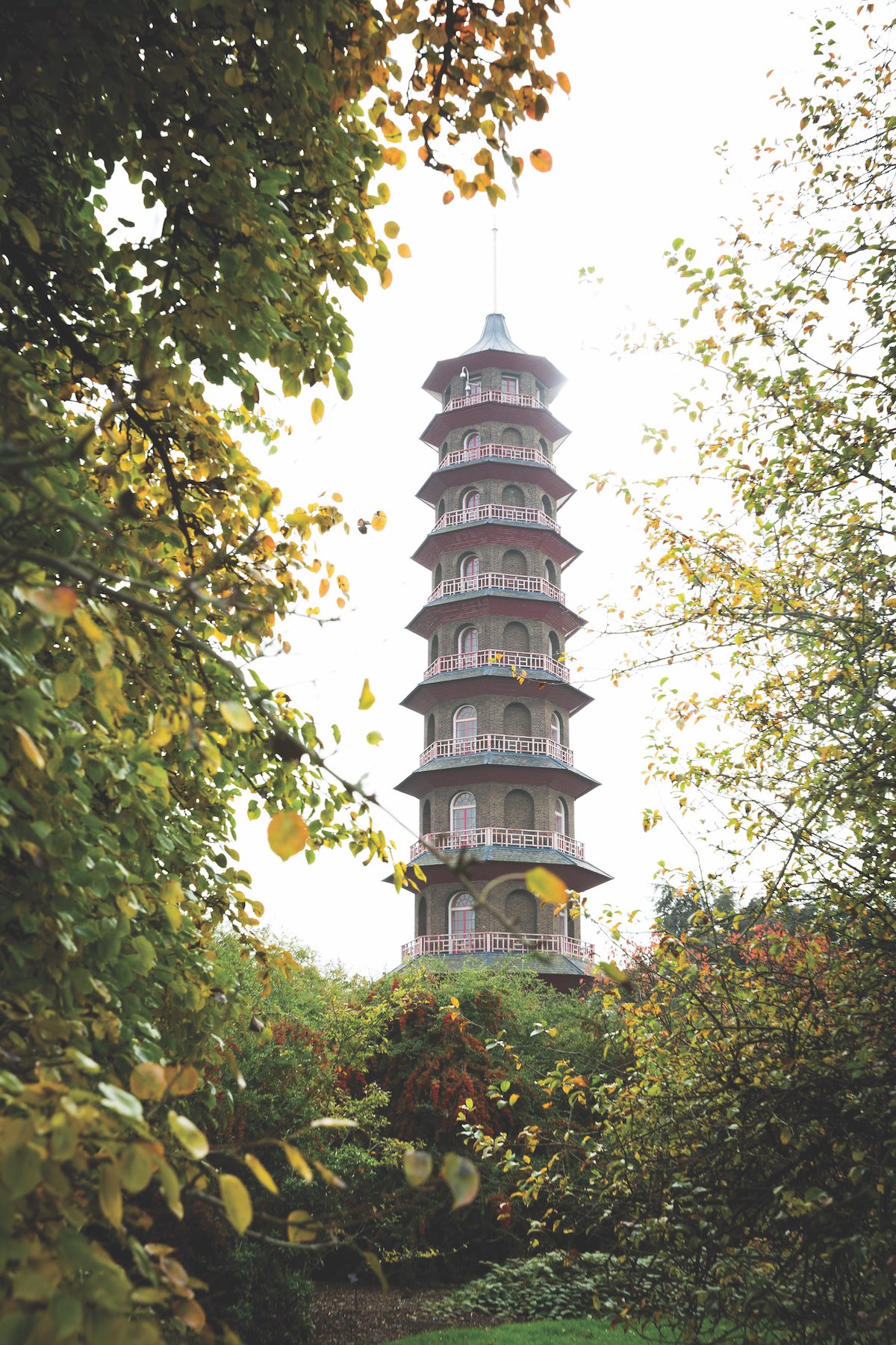 Tall Chinese-influenced tower in a green garden.