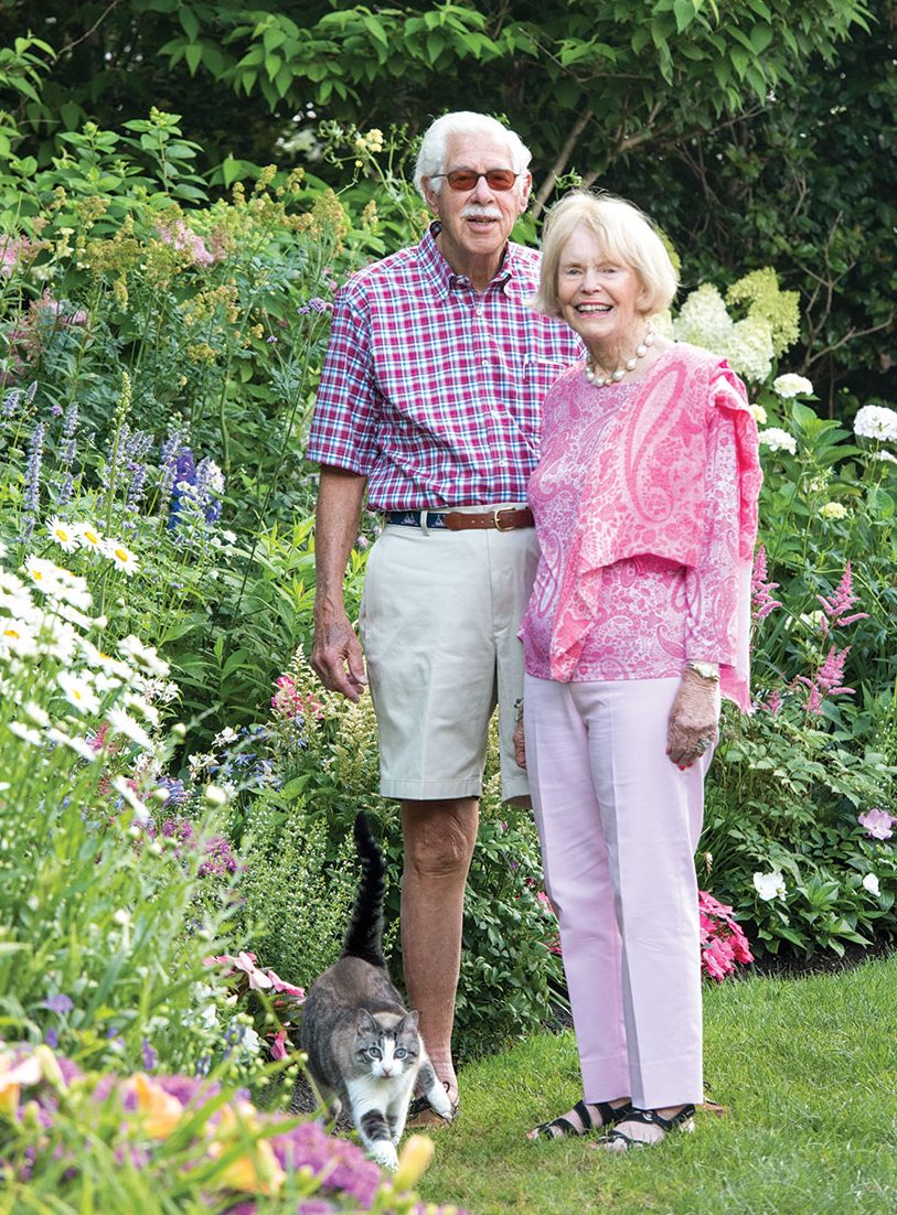 Couple stands in a garden.
