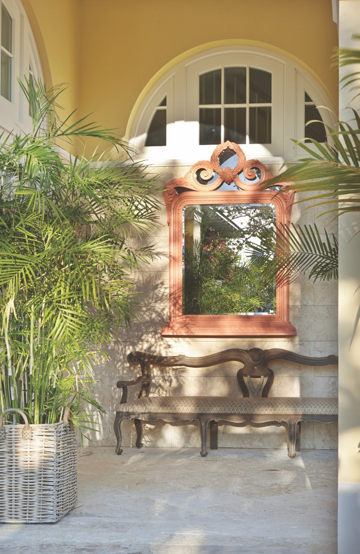 Amanda Lindroth designed loggia with fanciful bench and ornate mirror with coral-colored frame.
