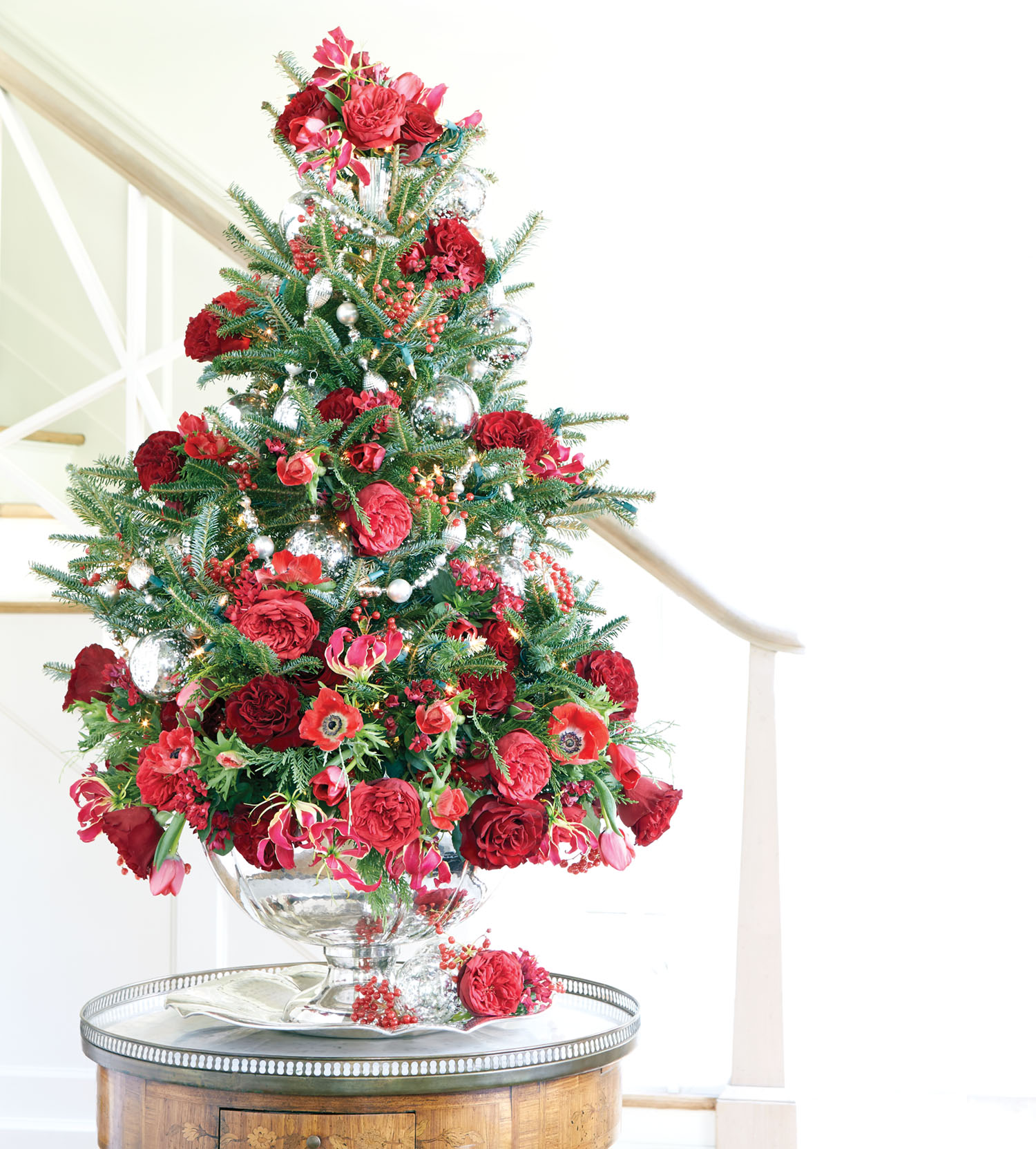 Ray Jordan's finished tabletop Christmas tree decorated with red flowers on an entry table.