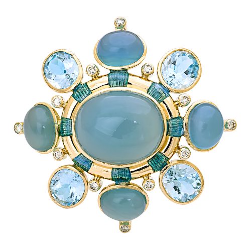 Photo of brooch featuring a large gray-blue oval center stone in a gold setting, ringed in 8 small diamonds and 8 stones alternating chalcedony and topaz