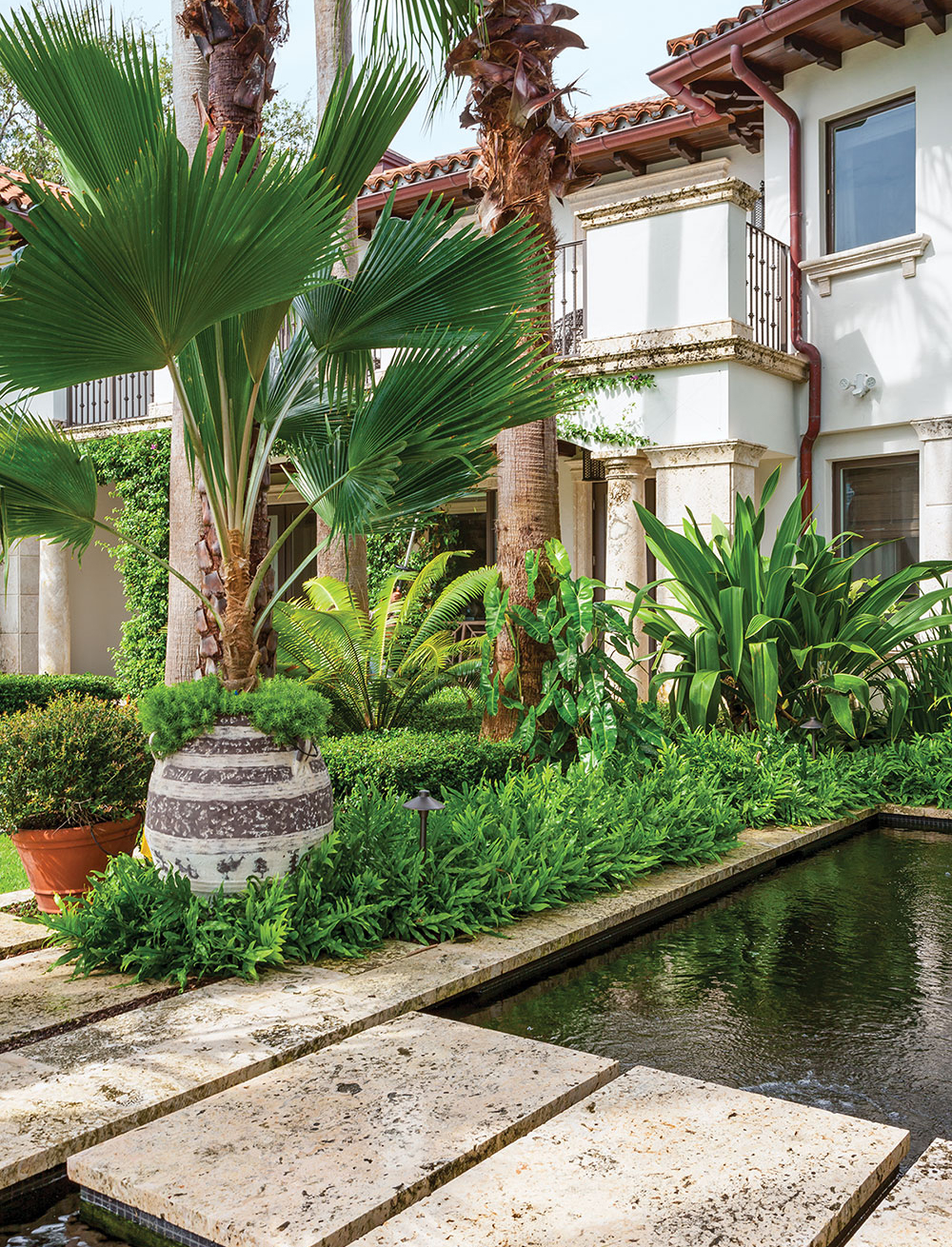 Limestone slabs create a path over ponds that house the owners’ collection of Asagi and Shusui koi. The urns are from Authentic Provence in West Palm Beach.