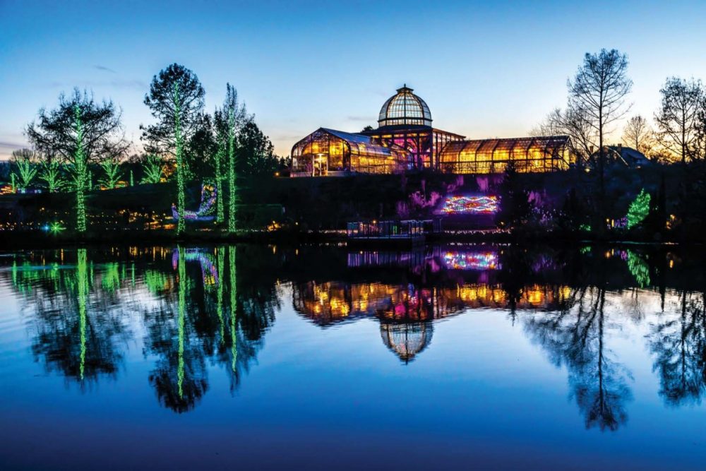 A must for holiday sightseeing in Richmond: An evening view of the massive glass conservatory, with the grounds of Lewis Ginter Botanical Garden decorated in holiday lights