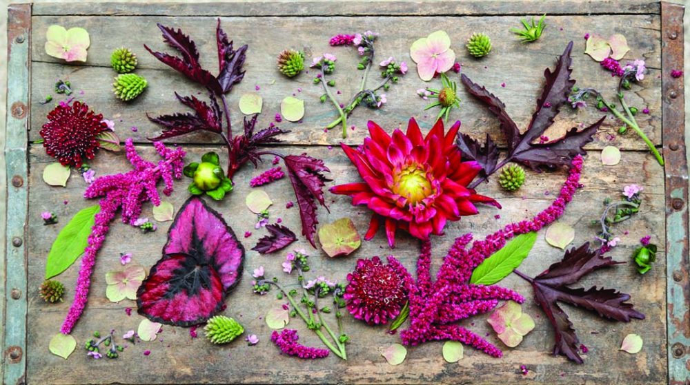 Flowers and leaves artfully arranged on a rustic wooden table at Strawberry Fields, one of designer Amanda Nisbet's picks for best shopping in Richmond, Virginia