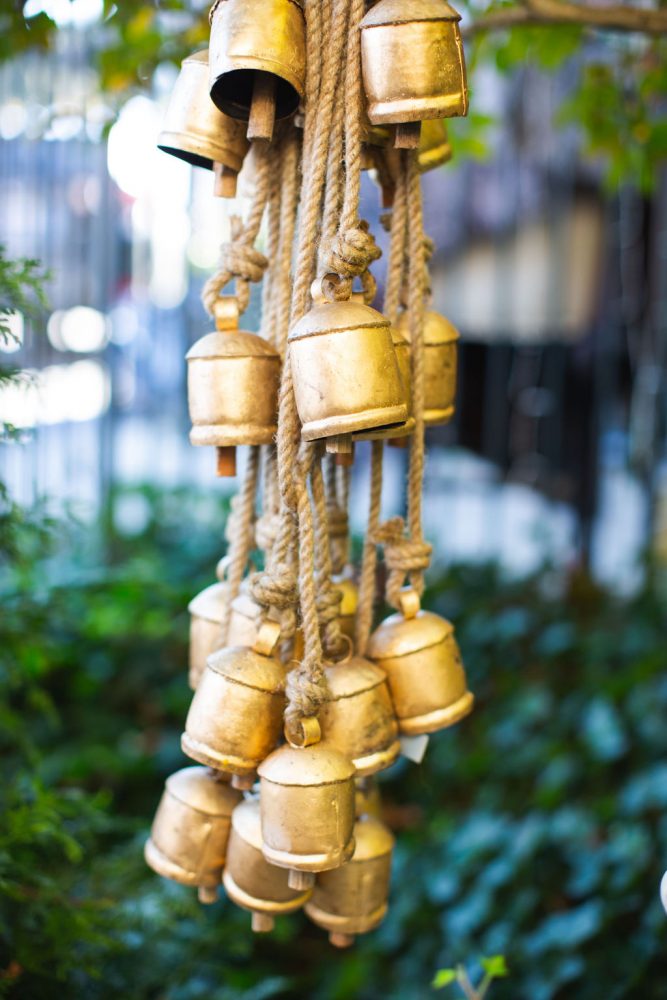 A bundle of antique holiday sleigh bells hanging from ropes