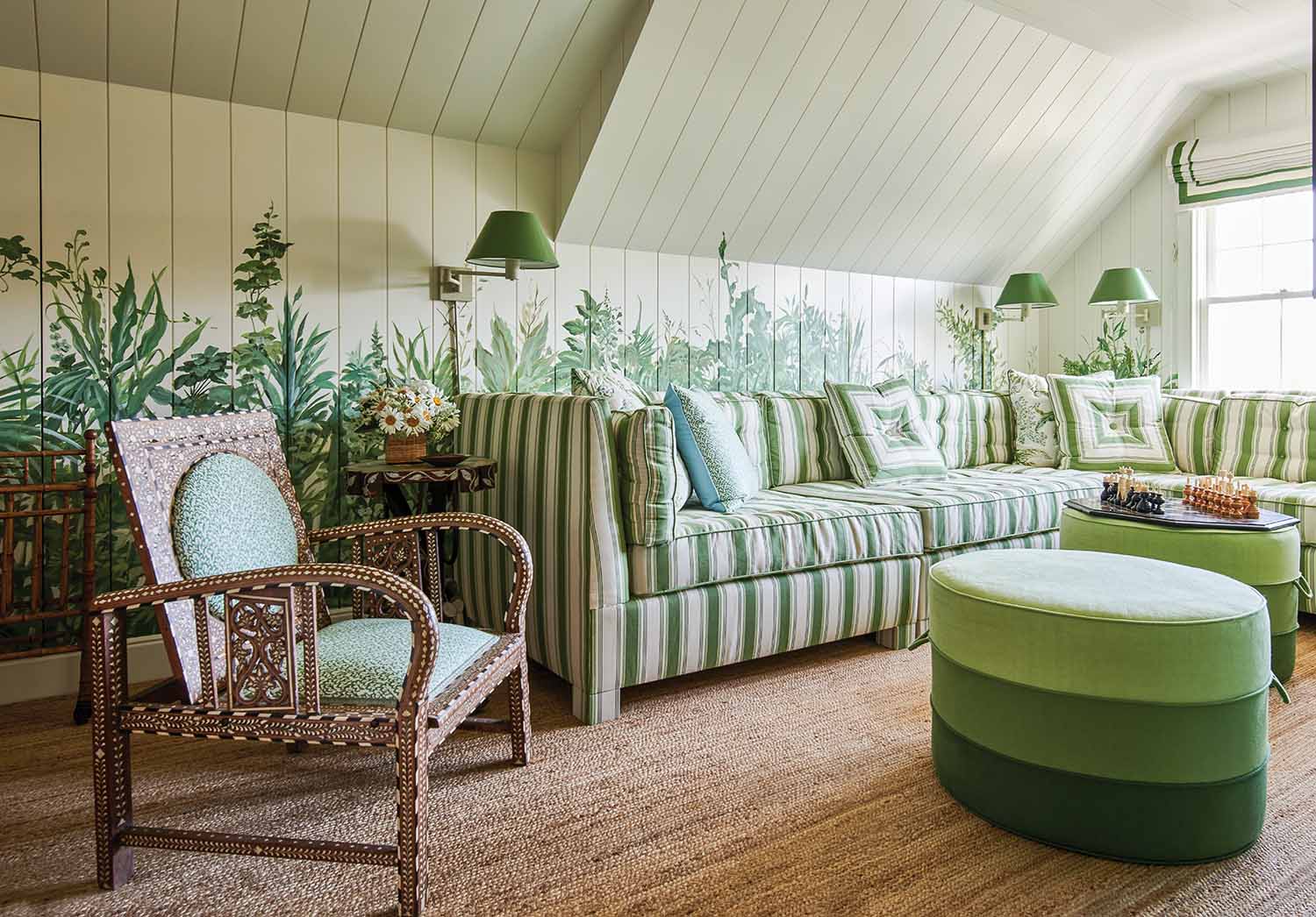 Liz Lange decorated her top floor sitting room in green with a striped couch, ottoman, and a leafy wallpaper.