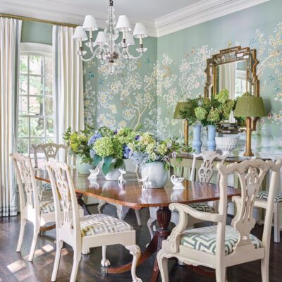 A chinoiserie wallpaper with a soft turquoise background envelope a bright dining room.