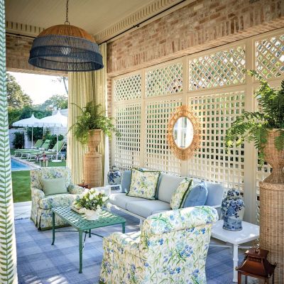 A cream colored lattice is the backdrop for a covered porch.