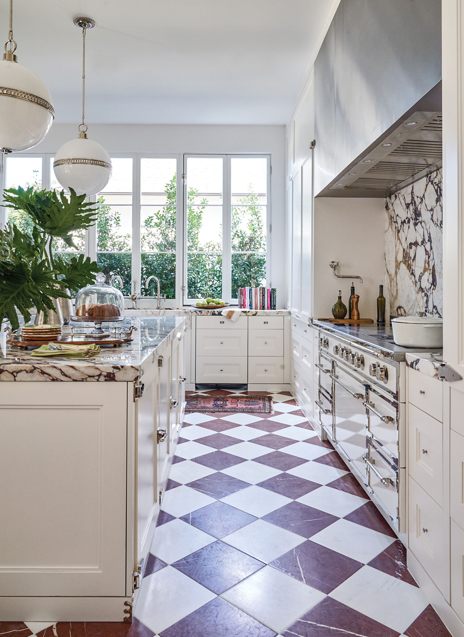 Cream colored kitchen cabinets and appliances with a brown checkerboard floor.