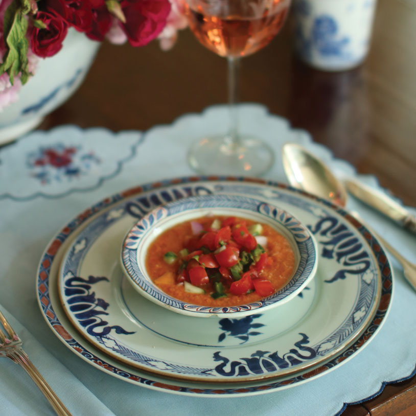 Small bowl of easy spicy gazacho, on blue and white table setting.