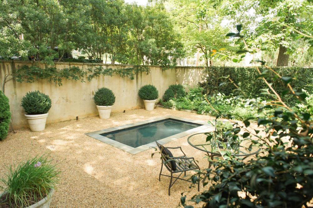 walled backyard with pond and pea gravel