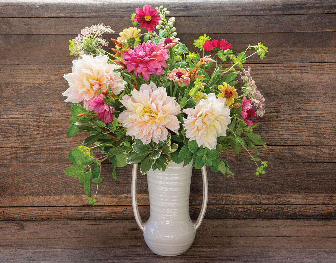 arrangement with pink dahlias and fragrant herbs