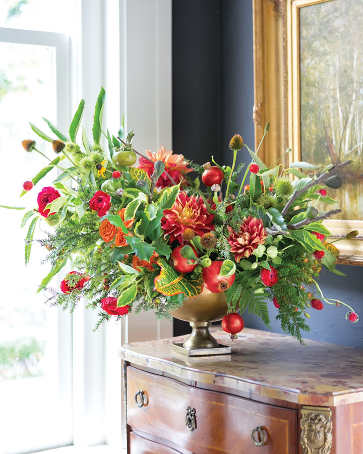 rust red and green holiday arrangement featuring dahlias