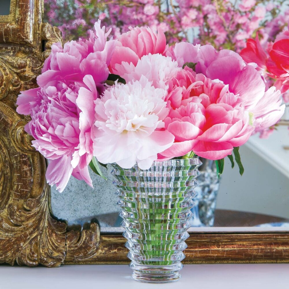 Pink peonies in Baccarat's Crystal Eye Vase. In the background stands an ornate gilt frame mirror