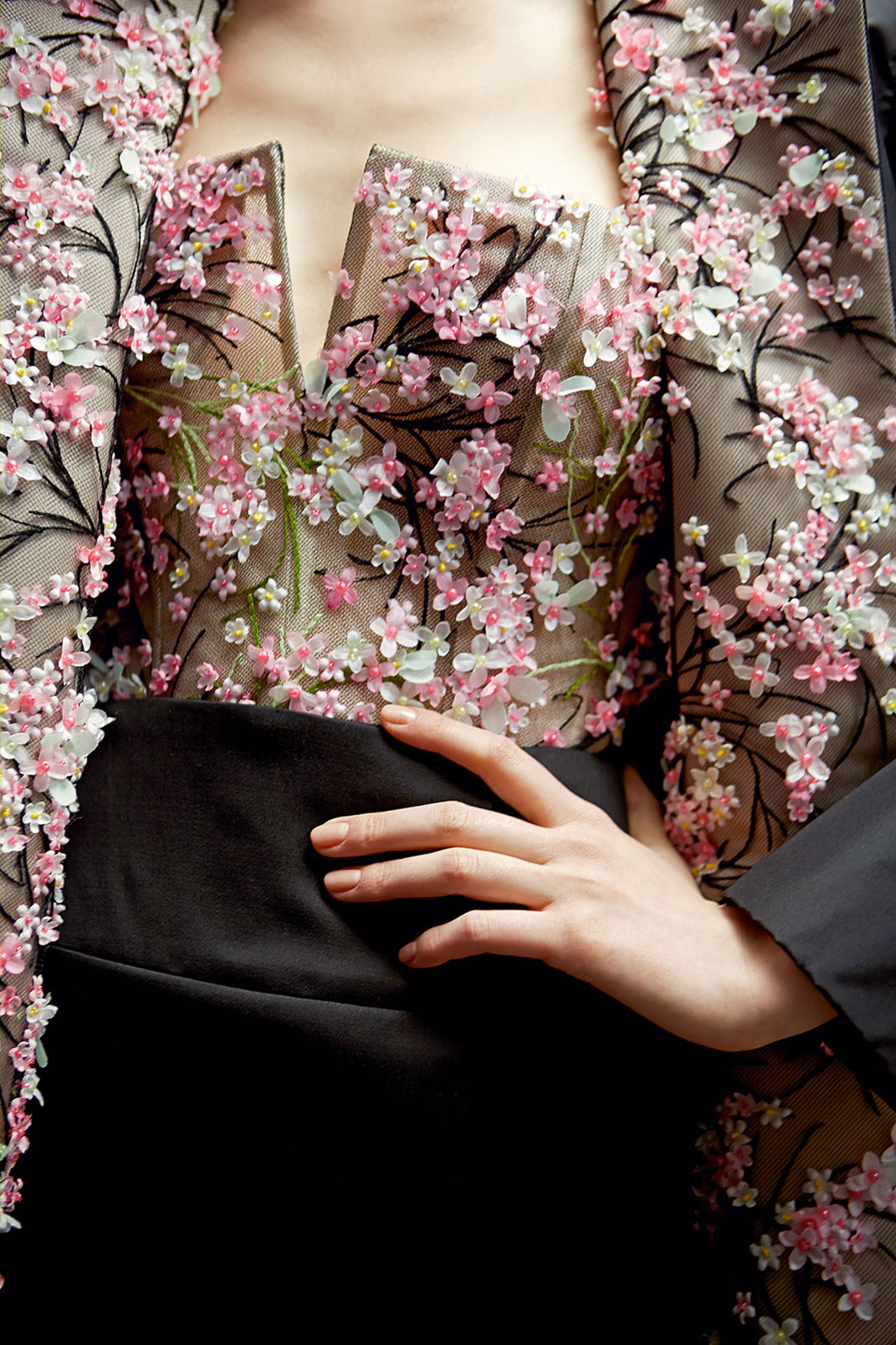 High fashion photo of a model wearing a floral Dior blouse and black skirt
