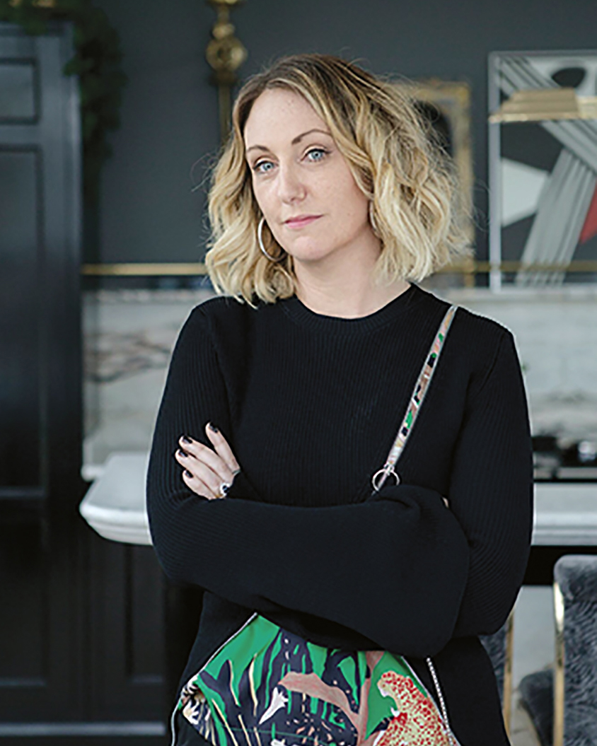 portrait of the Irish artist Eva O'Donovan, wearing black and carrying a colorful, floral fabric shoulder bag