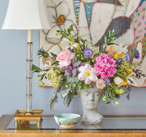 Floral design by The French Potager featuring spring flowers in a concrete cast bust