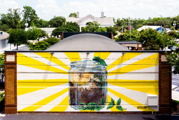 The birthplace of sweet tea mural, featuring a large jar of iced tea radiating yellow rays in Summerville, South Carolina