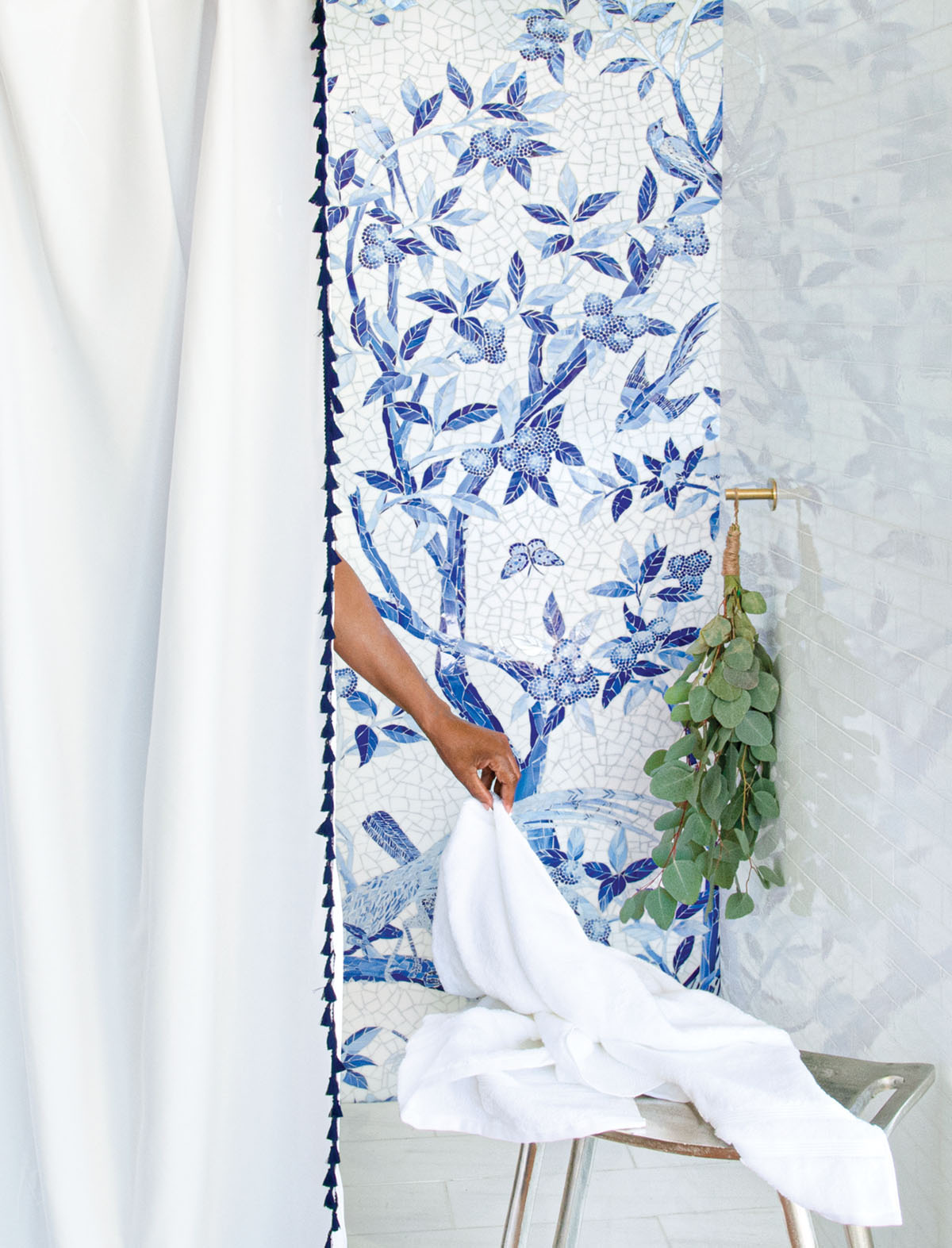 shower wall titled with a blue-and-white mosaic