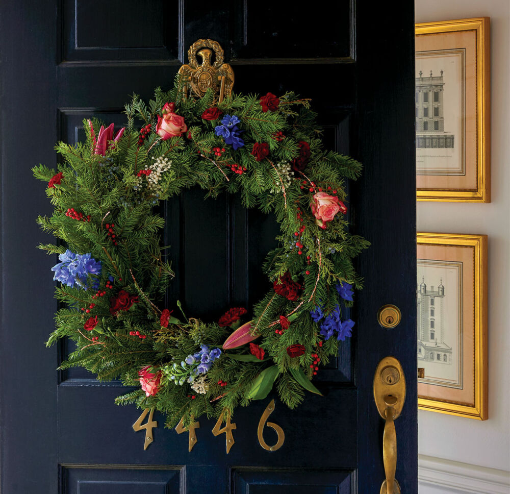 Evergreen Christmas wreath with roses, lilies, and other fresh flowers.
