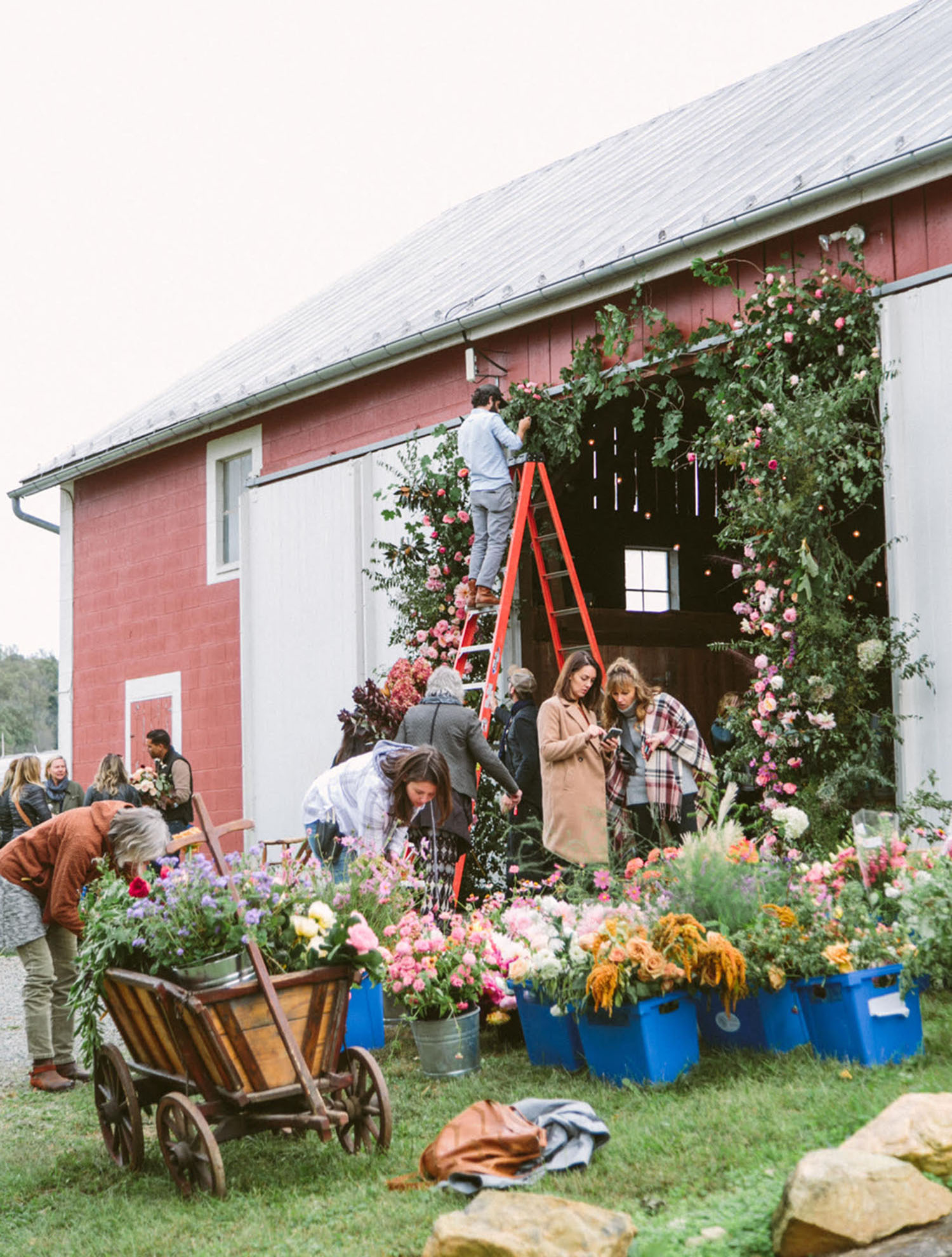 Holly Heider Chapple's team works on a floral arch to the entrance of the Bank Barn at Hope Flower Farm