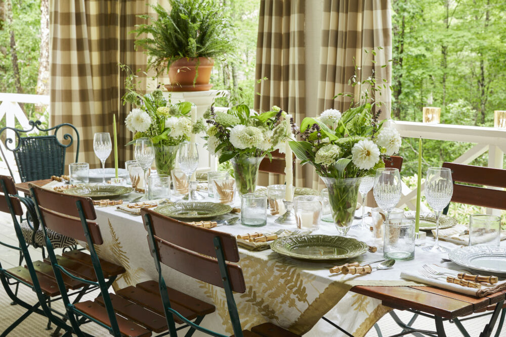 Table set with green and white table cloth, and flower arrangements
