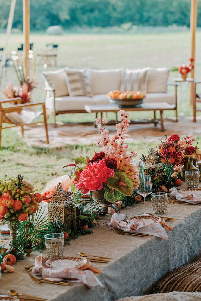 A tablescape of peonies, ranunculus, and citrus fruits at Camp Round Top