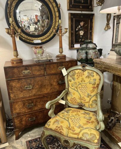 Antique yellow chair, wooden chest, round mirror in Peachtree Battle Antiques