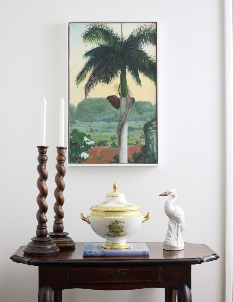 Painting of a Cuban landscape slips perfectly into the kitchen with its greens and hints of yellow.