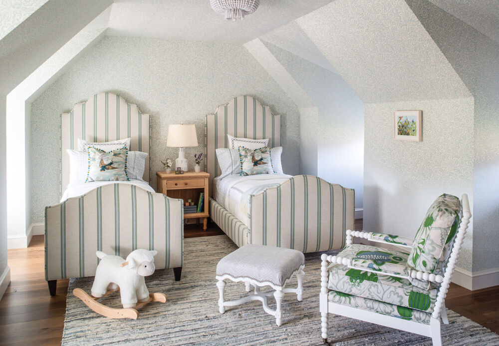 Childrens' bedroom with pair of upholstered twin beds, blue floral wallpaper covers walls and ceiling.
