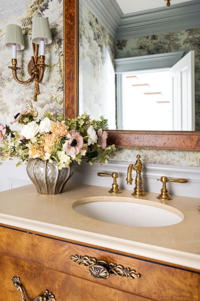 Powder room sink with Waterworks fixtures, ceramic vase filled with anemones, ranunculus, and oakleaf hydrangea blossoms.