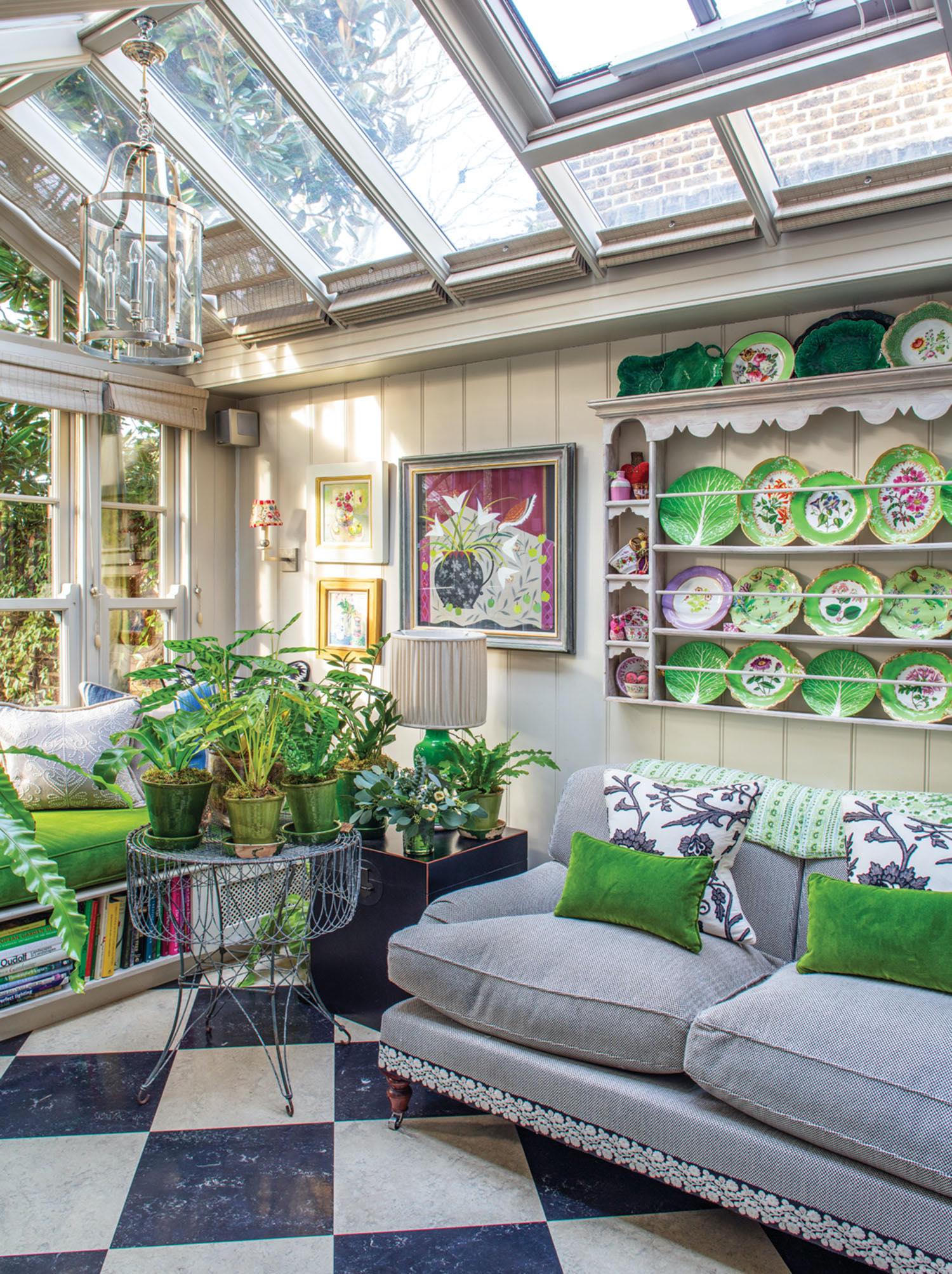 The conservatory, with views of the garden, is painted a soothing gray with strong accents of green.