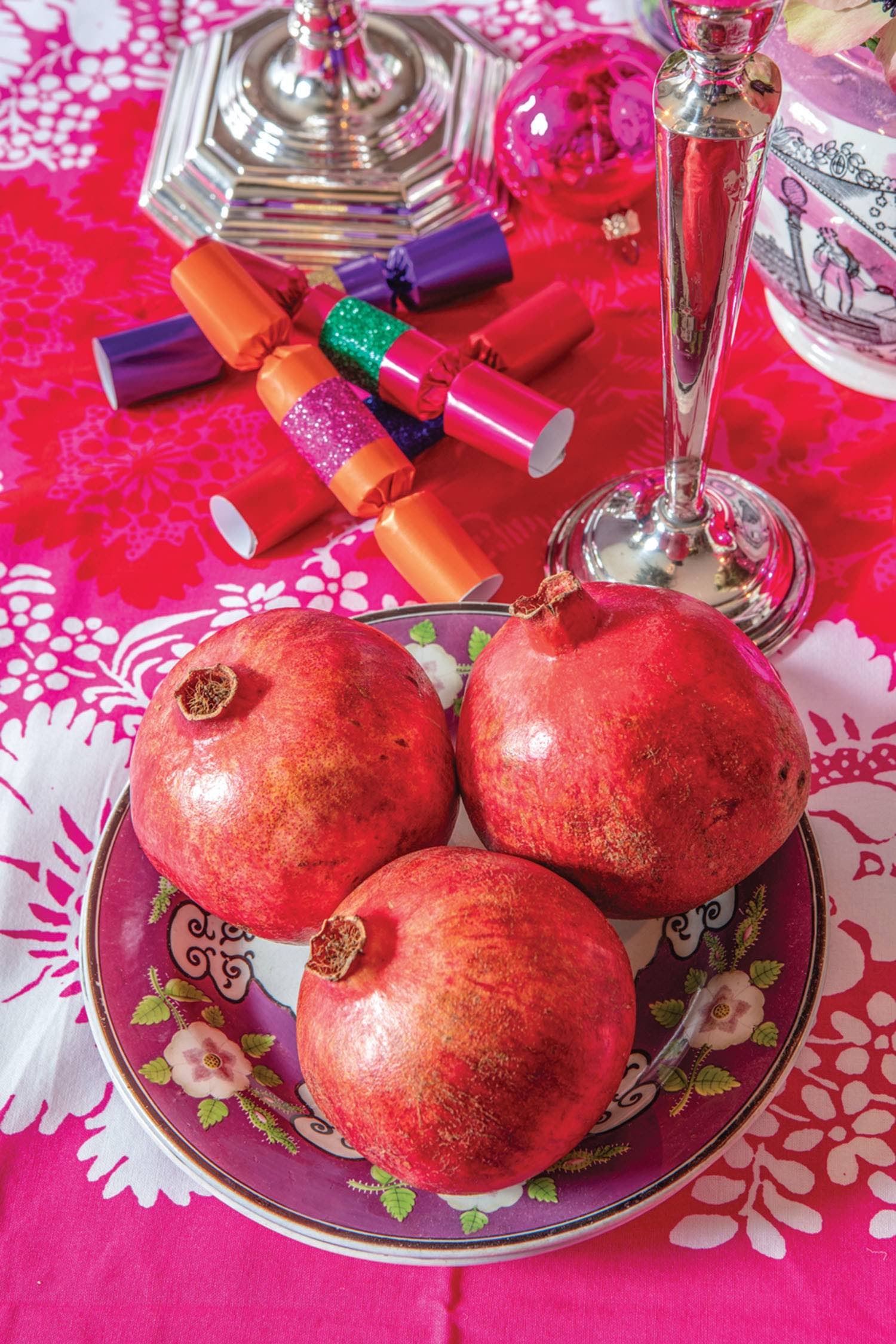 A bowl of pomegranates at the table.