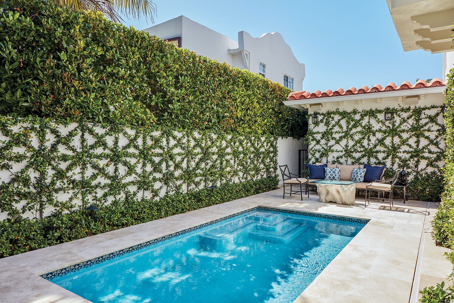 A geometric design of confederate jasmine defines the pool area of a Palm Beach home