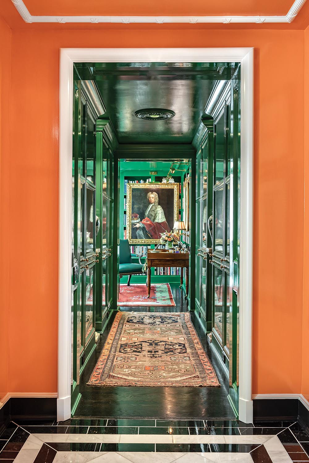 An orange hallway leads to a deep green hallway.