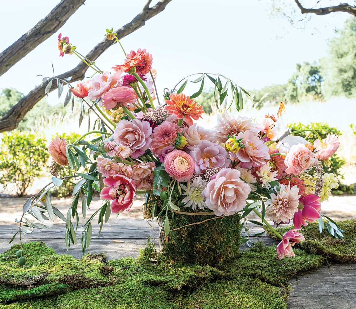 Frances Schultz arrangement features pink-hued ranunculus, tulips, yarrow, garden dahlias, zinnias, roses, and olive foliage.