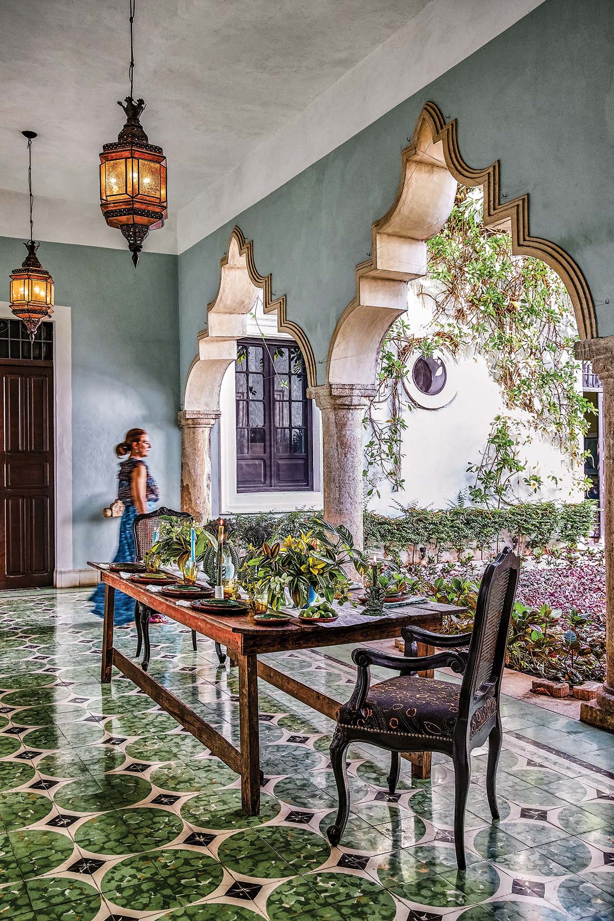 Ariella Chezar walks around a floral table in a Moroccan-inspired room.