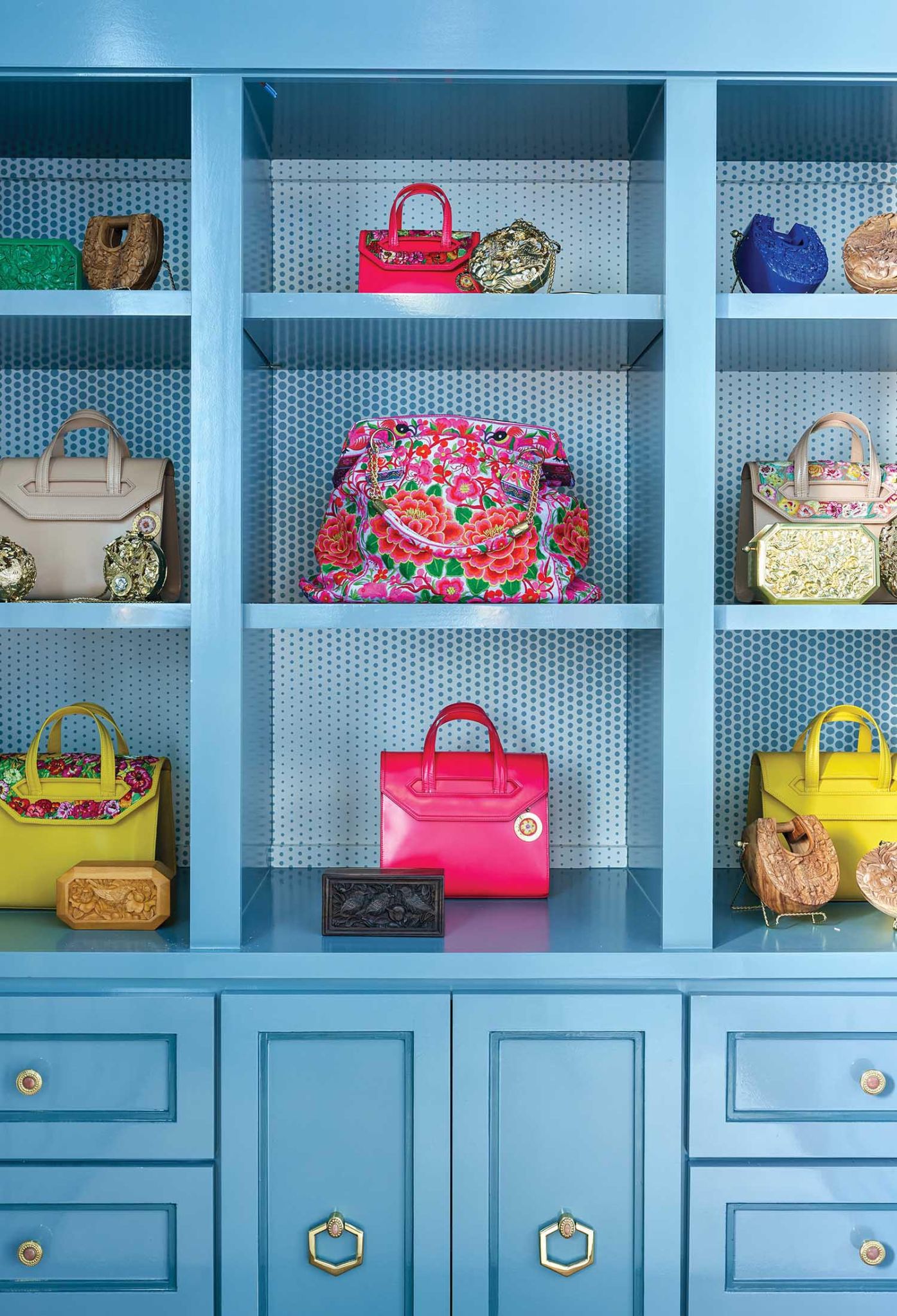 Blue cabinets hold colorful handbags.