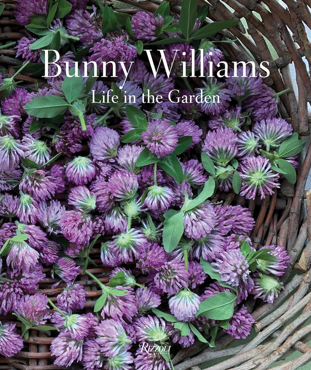 Purple thistle flowers lay in a basket on the cover of Bunny Williams's LIFE IN THE GARDEN.